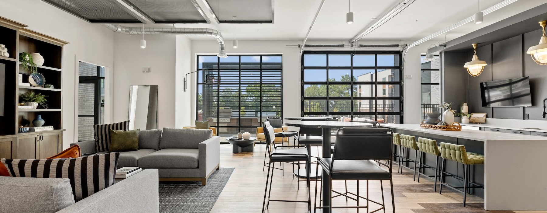 Resident clubhouse with couches and tables at Bowery West modern apartments and townhomes in Charlotte, NC